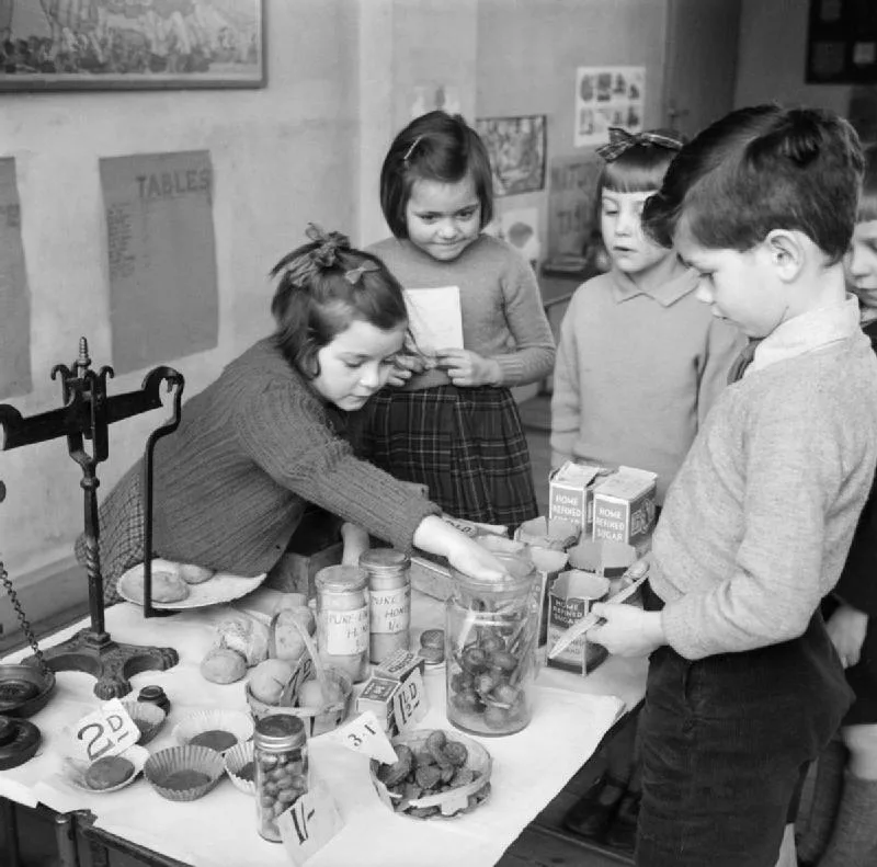 Children doing sums in a grocery shop set up inside a classroom, 1944